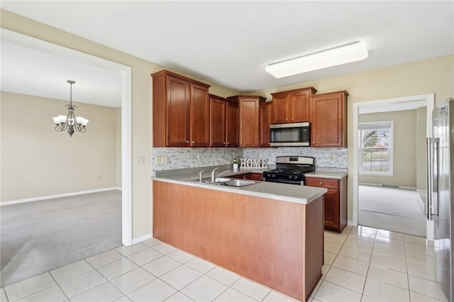 kitchen with light tile patterned flooring, sink, kitchen peninsula, stainless steel appliances, and decorative backsplash