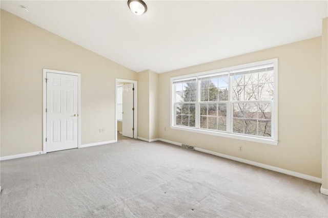 carpeted spare room with lofted ceiling