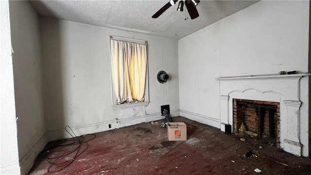 unfurnished living room featuring ceiling fan and a textured ceiling