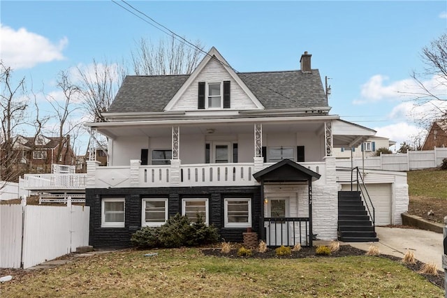 view of front of home with a garage, a porch, and a front lawn