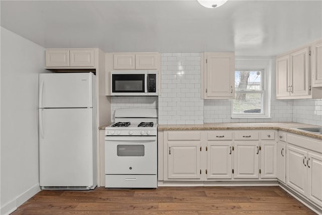 kitchen with white cabinetry, light wood-type flooring, white appliances, and decorative backsplash