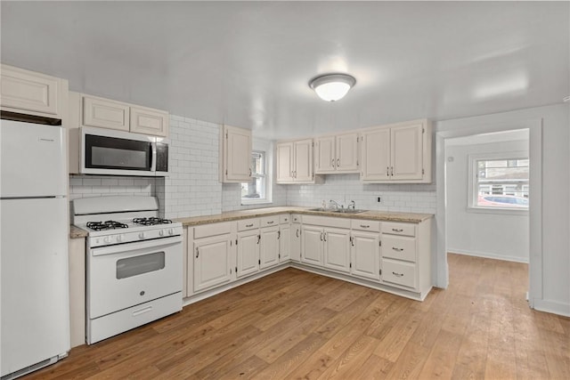 kitchen featuring sink, white appliances, decorative backsplash, and white cabinets