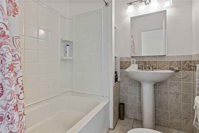 bathroom with shower / bath combination with curtain, toilet, tile patterned flooring, and tile walls