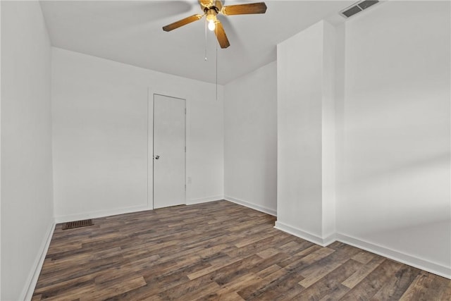 spare room featuring dark wood-type flooring and ceiling fan