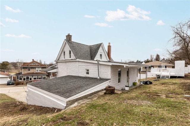 back of property with a wooden deck and a yard