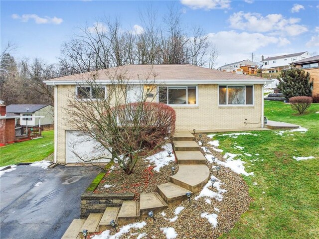 view of front of home featuring a garage and a front lawn