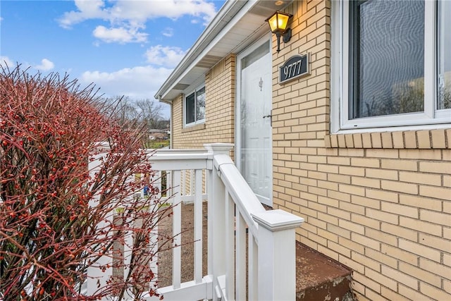 doorway to property featuring brick siding