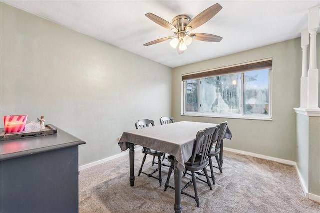 dining area featuring a ceiling fan, light colored carpet, and baseboards