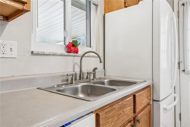 kitchen featuring light countertops, brown cabinetry, and a sink