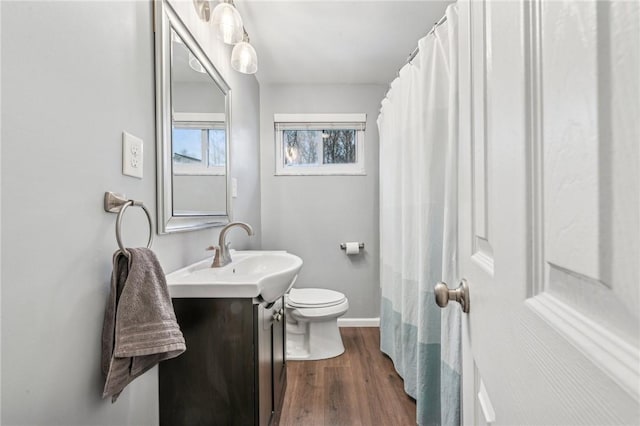 full bathroom featuring toilet, wood finished floors, vanity, and baseboards