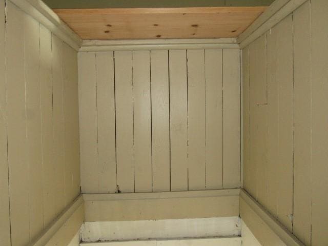 bathroom with wooden ceiling and wooden walls