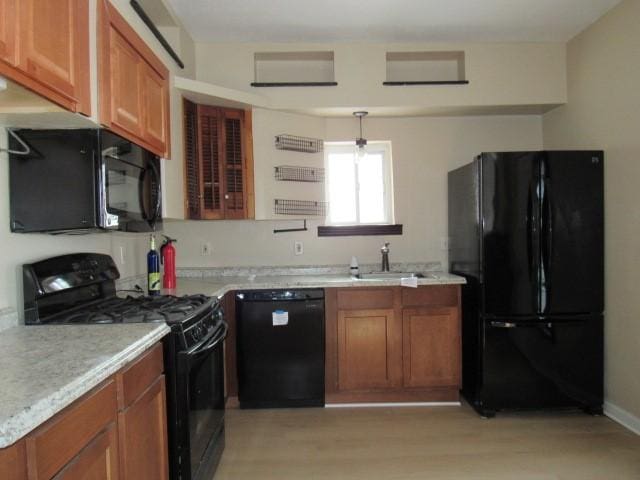 kitchen with light wood-type flooring, sink, and black appliances