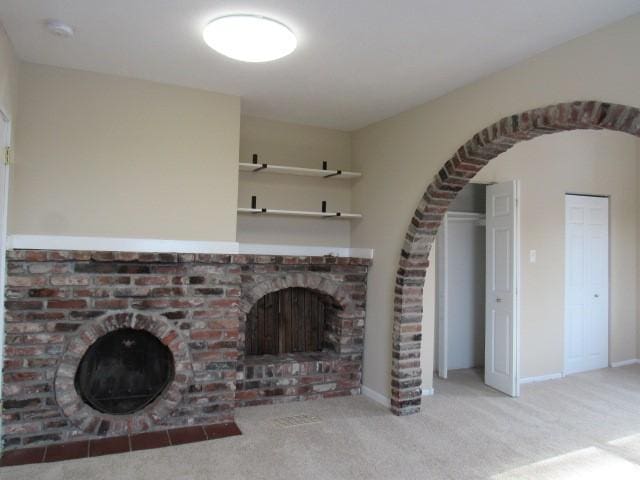 unfurnished living room featuring light colored carpet and a fireplace