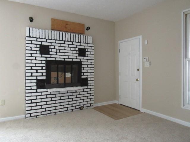 unfurnished living room with carpet flooring and a fireplace