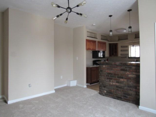 kitchen featuring pendant lighting, light colored carpet, and kitchen peninsula