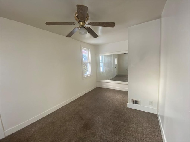 empty room featuring dark colored carpet and ceiling fan