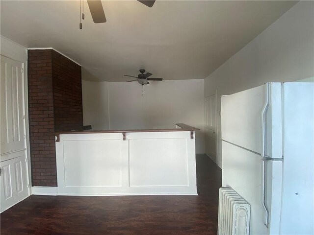 kitchen featuring white refrigerator, ceiling fan, radiator, and dark wood-type flooring