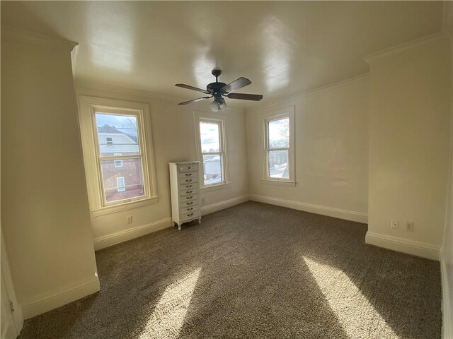 carpeted spare room featuring ornamental molding and ceiling fan