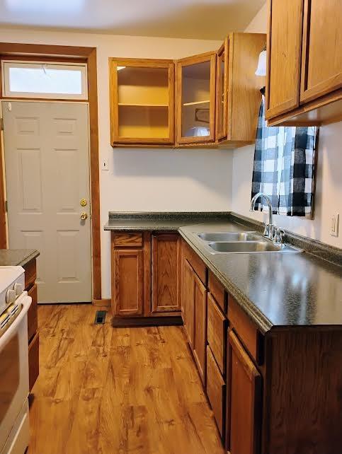 kitchen featuring white range with electric cooktop, sink, and light hardwood / wood-style flooring