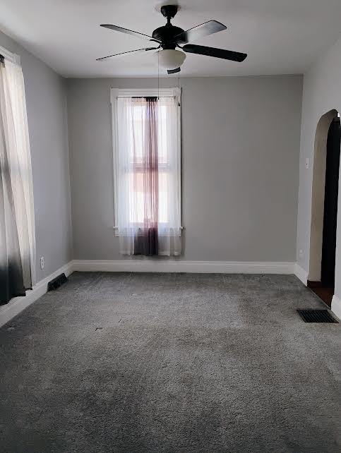 carpeted empty room featuring ceiling fan