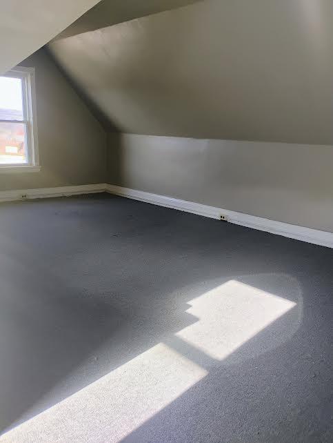 additional living space featuring lofted ceiling