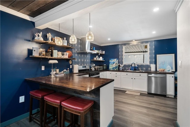 bar featuring wall chimney exhaust hood, sink, white cabinetry, appliances with stainless steel finishes, and pendant lighting