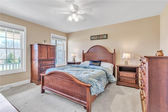 carpeted bedroom featuring multiple windows and ceiling fan