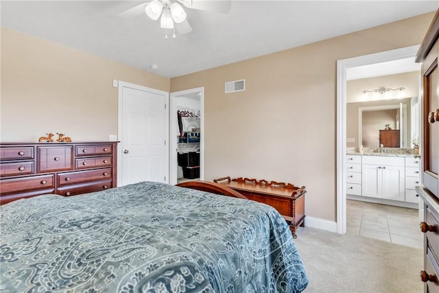 carpeted bedroom featuring ceiling fan and ensuite bathroom