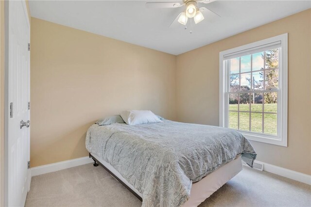 carpeted bedroom featuring ceiling fan and multiple windows