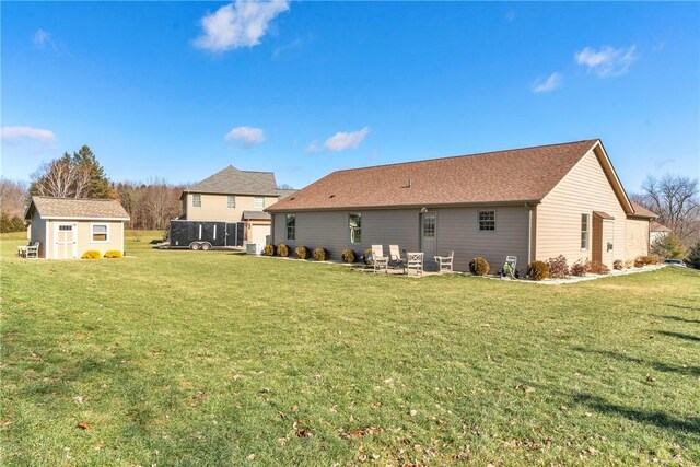 back of property with a shed and a yard