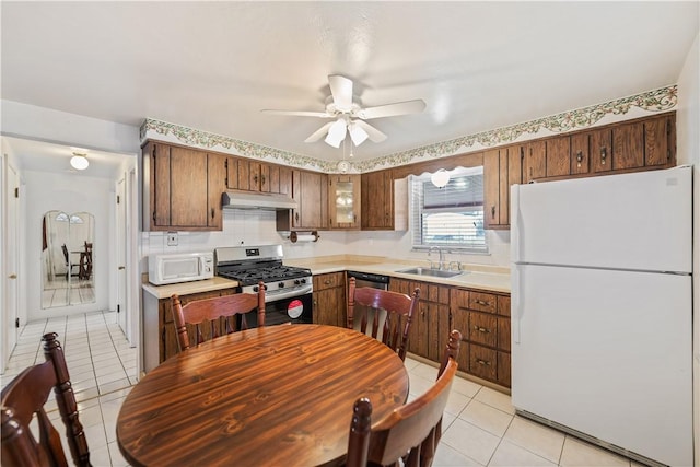 kitchen featuring ceiling fan, sink, light tile patterned flooring, and white appliances