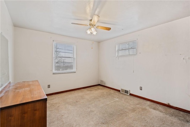 carpeted spare room with ceiling fan