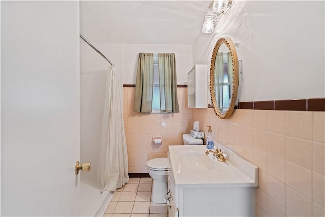 bathroom featuring tile patterned floors, toilet, tile walls, and vanity