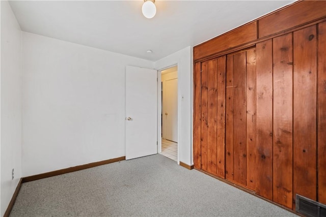 unfurnished bedroom featuring light colored carpet and a closet