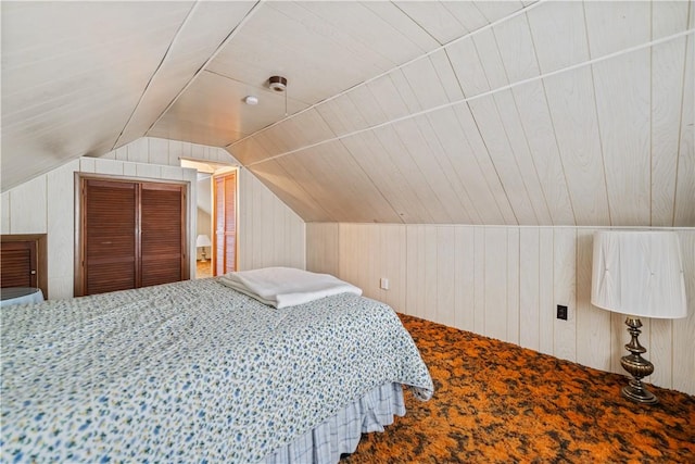 carpeted bedroom featuring wooden walls and vaulted ceiling