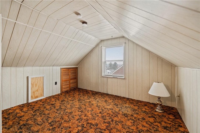 bonus room with lofted ceiling, carpet floors, and wood walls