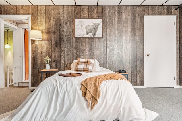 carpeted bedroom with wooden walls