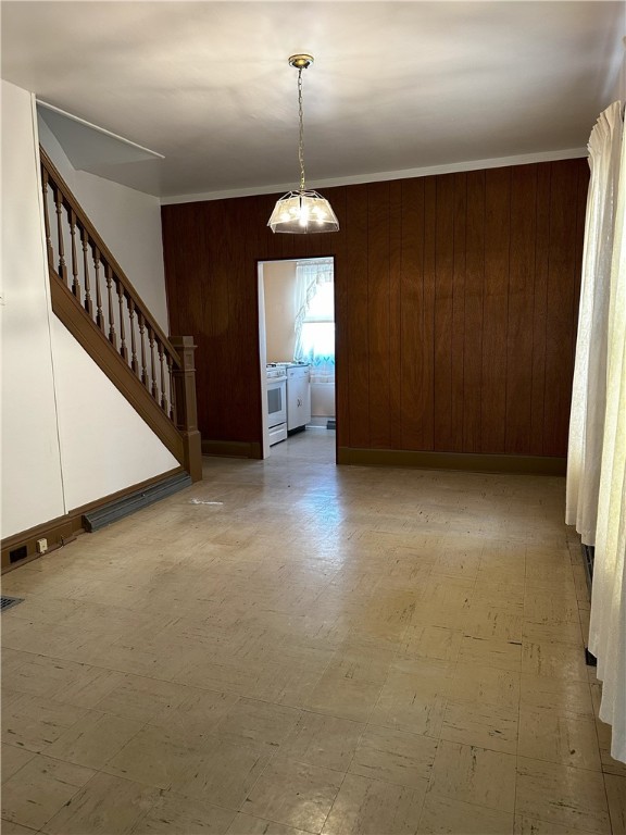 unfurnished dining area featuring wooden walls