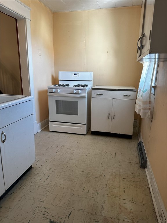 kitchen featuring white gas range and white cabinets