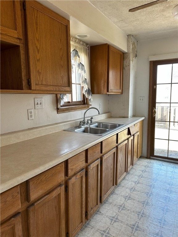 kitchen featuring sink, a textured ceiling, and a wealth of natural light