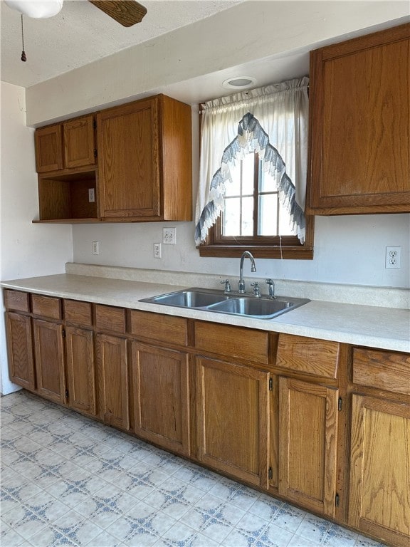 kitchen featuring ceiling fan and sink