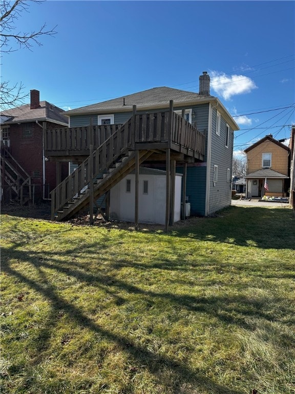 rear view of property with a deck and a lawn