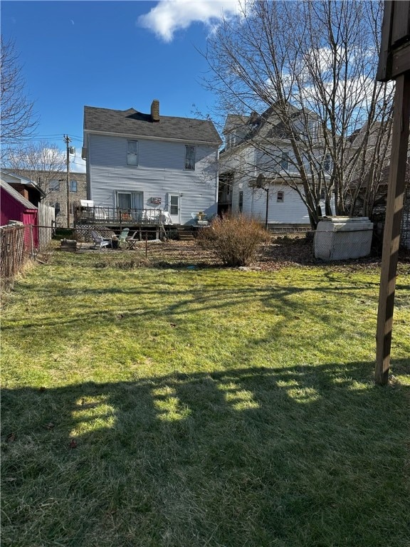 rear view of house with a yard and a deck