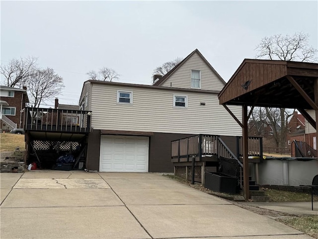 back of house with a garage and a deck