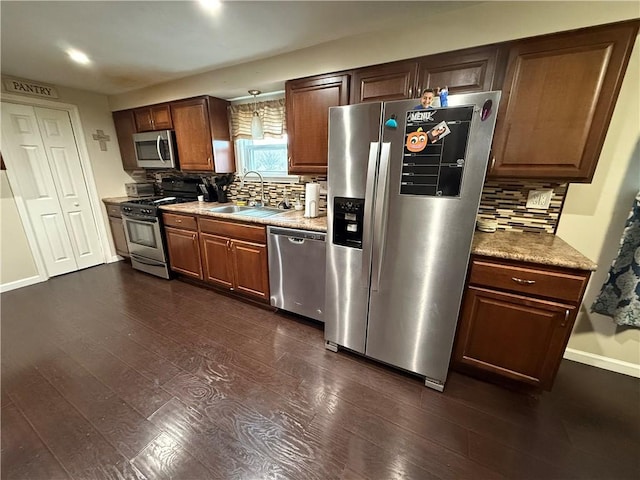 kitchen featuring stainless steel appliances, tasteful backsplash, sink, and dark wood-type flooring