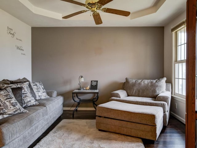 living room with hardwood / wood-style flooring, a raised ceiling, and a wealth of natural light