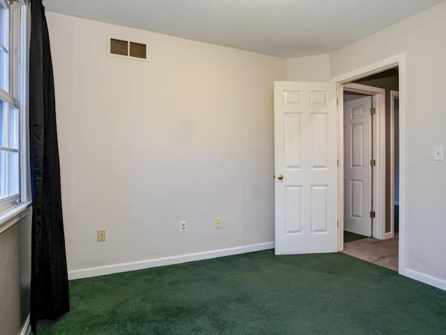 empty room featuring dark carpet