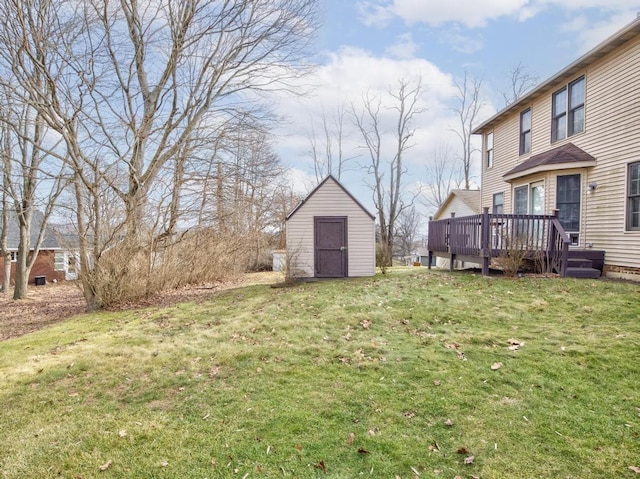 view of yard featuring a wooden deck and a storage shed