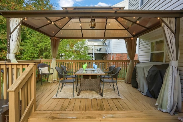 wooden terrace with area for grilling and a gazebo