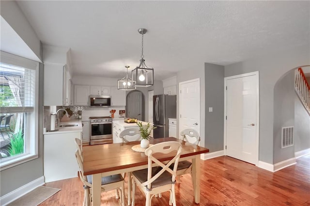 dining room with sink and light wood-type flooring